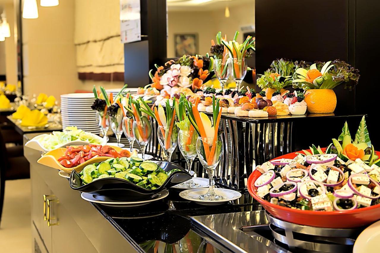 Al Ghufran Safwah Hotel Makkah Mekka Buitenkant foto The photo displays a beautifully arranged buffet featuring a variety of colorful and fresh food items. There are several plates and bowls filled with salads, including a mix of greens, chopped vegetables, and potentially some fruits. 

In the foregro